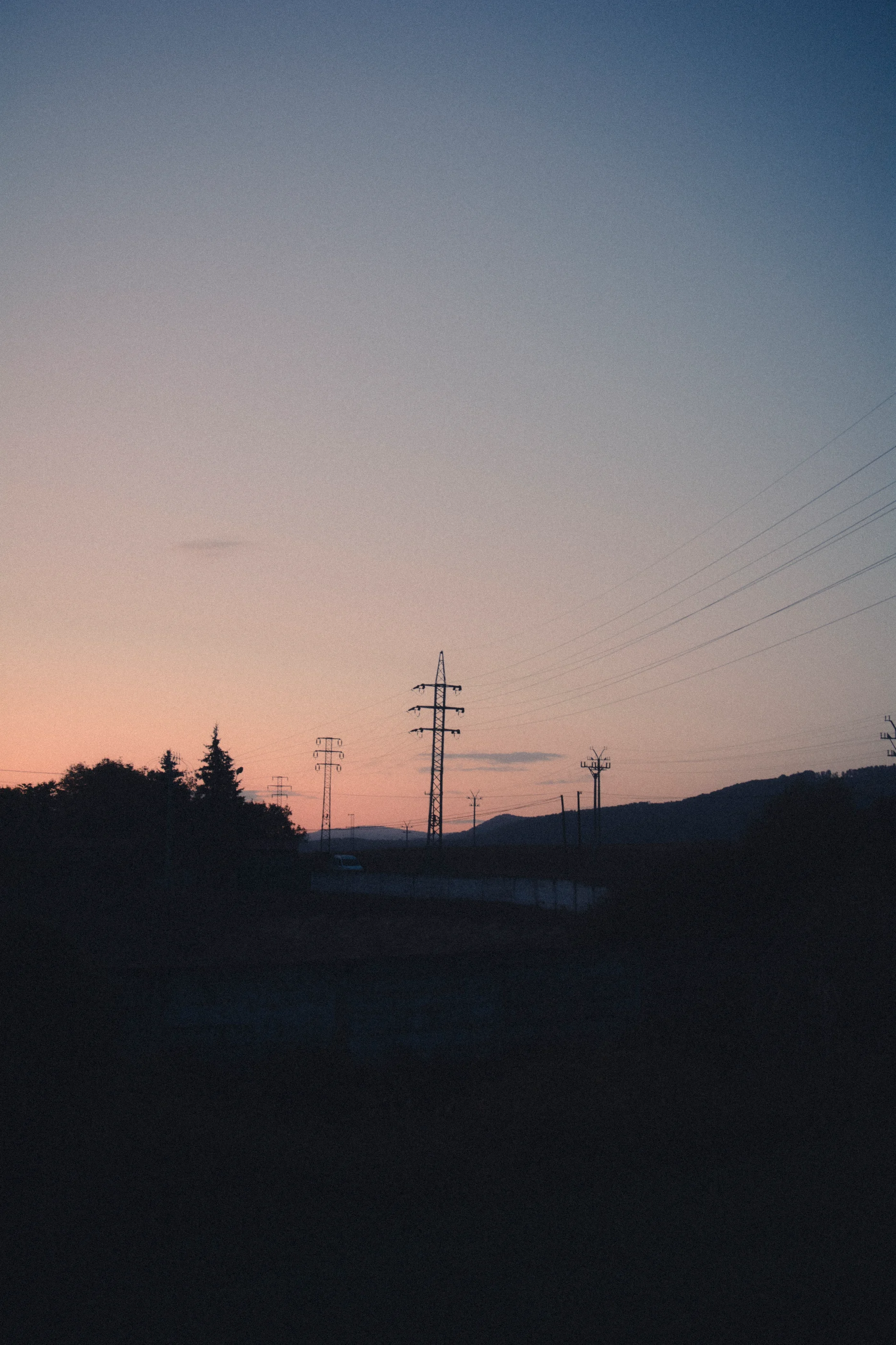 Elektrické stožiare pod teplou večernou oblohou